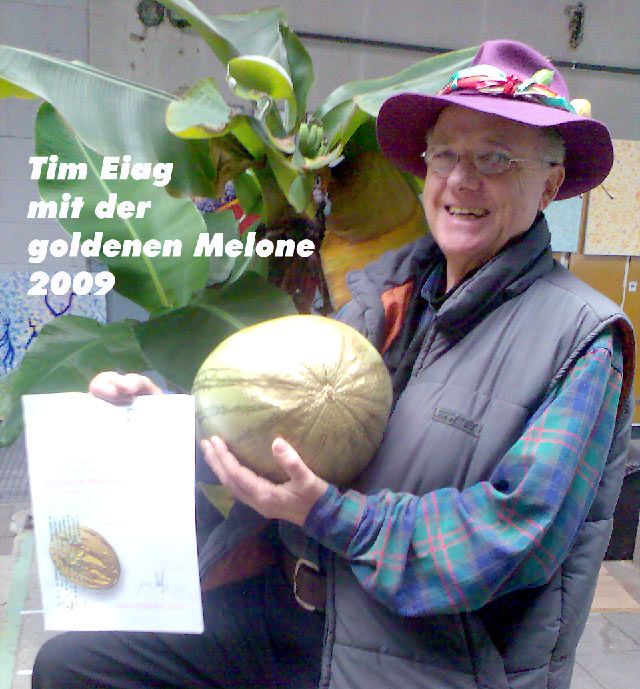Tim Eiag, gl&uuml;cklich mit der goldenen Melonen2009, vor einer ausgewachsenen Bananenstaude